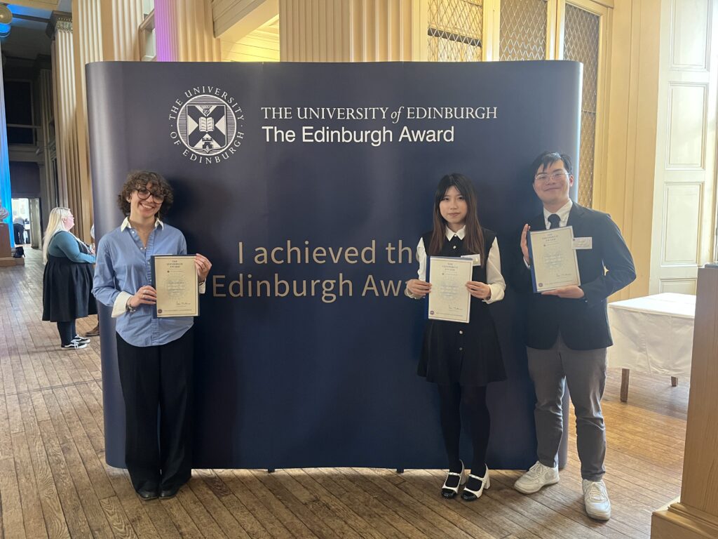 Award achievers gathered in the Playfair Library at the award celebration and holding up their award certificates.
