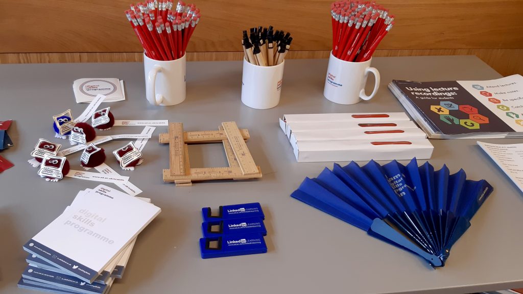 Various Digital Skills branded merchandise including pencils, pens, fans and notepads.